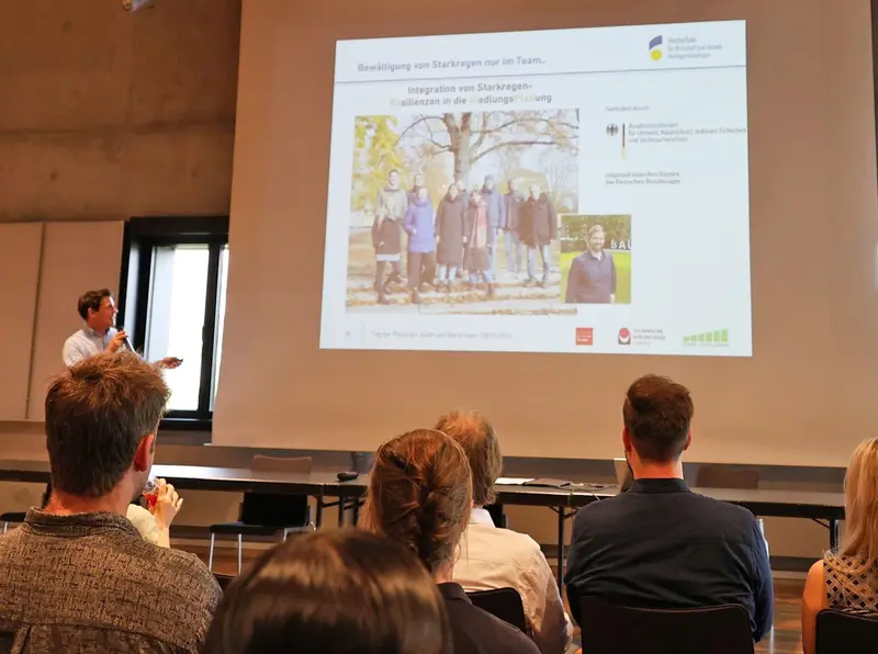 Professoren vor einem Begrüßungsplakat 