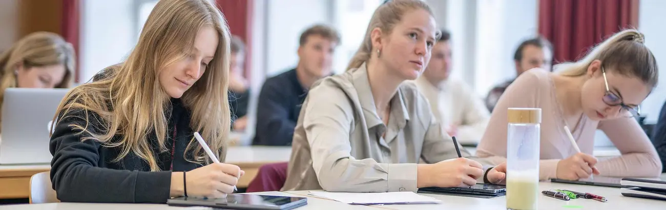 Das Bild zeigt Studierende in einer Vorlesungssituation