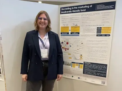 Sanja stellt auf einer Konferenz ihre Forschung auf einem Poster vor