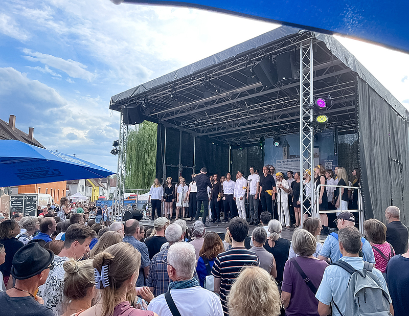 Chor auf Bühne mit zahlreichem Publikum
