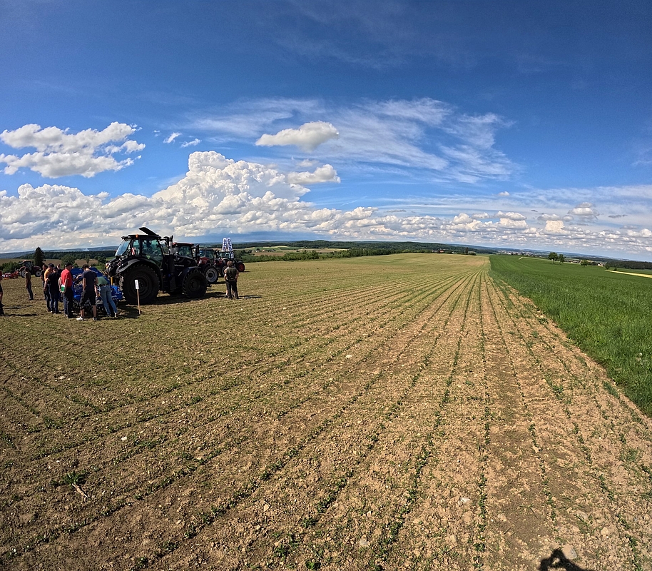 Zuhörer mit Traktor auf dem Feld