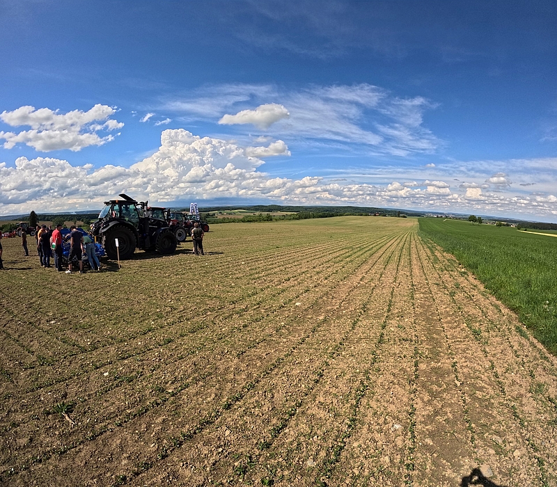 Zuhörer mit Traktor auf dem Feld