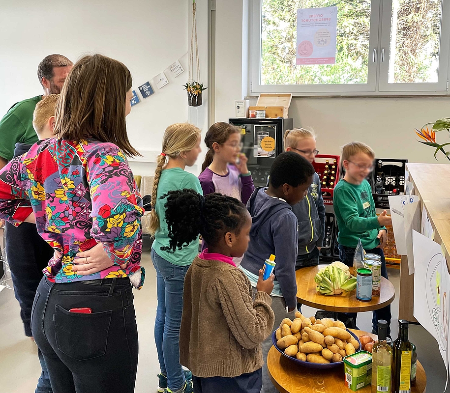 Kleine Gruppe von Kindern vor den Gefäßen mit den Zutaten.