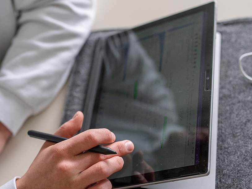 Arm und Hand einer Person, die Tablet nutzt