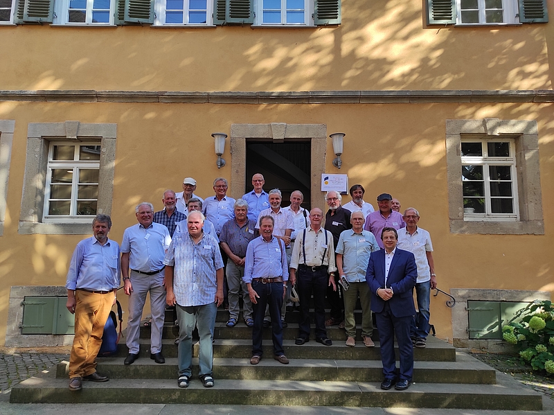 Alumni der HfWU stehen vor der ehemaligen Turnhalle.