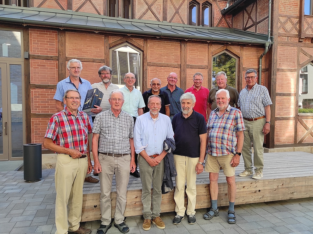 Alumni der HfWU stehen vor der ehemaligen Turnhalle.