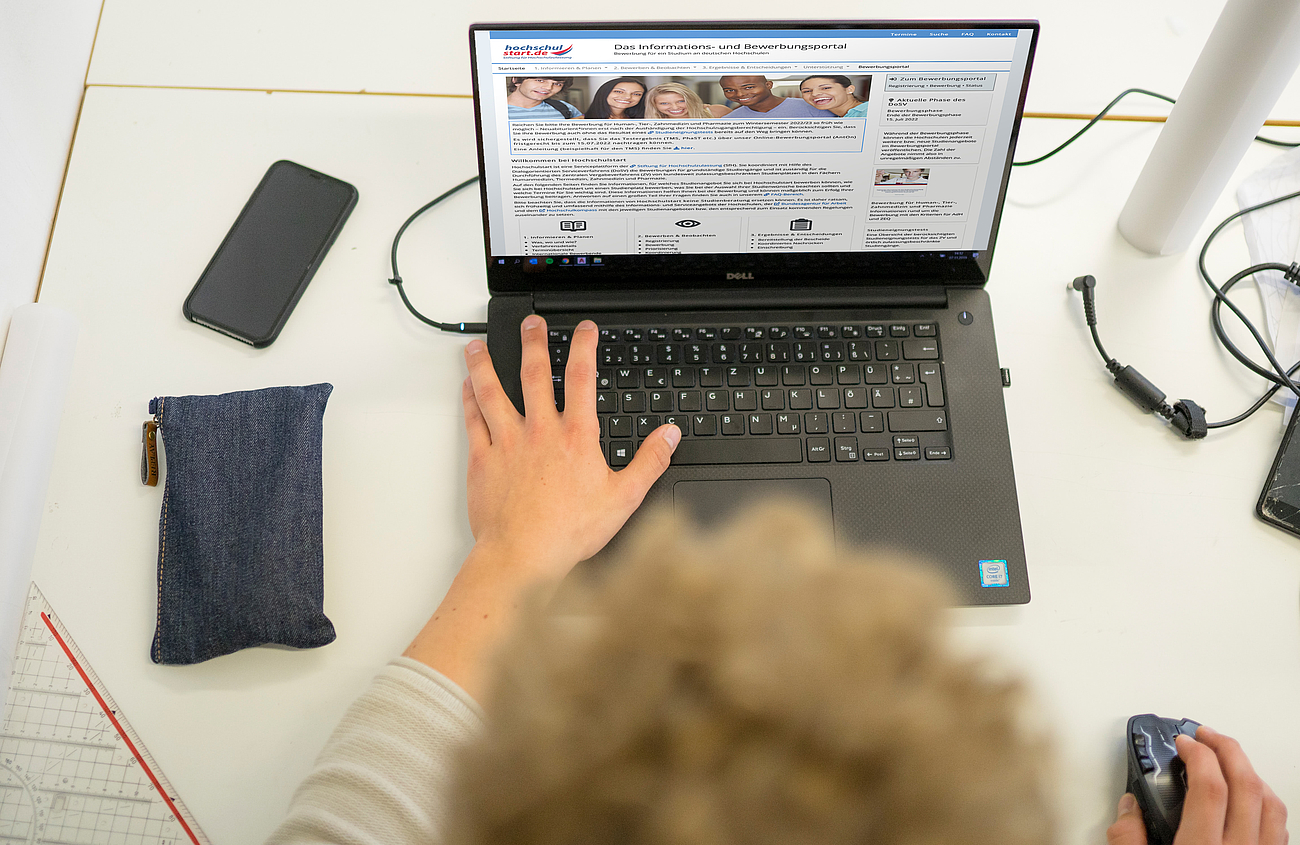 Bewerben auf Hochschulstart Foto eines Studieninteressierten, der am Laptop die Website Hochschulstart.de besucht