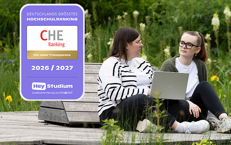 zwei Studierende im Grünen, CHE-Sigel im Bild