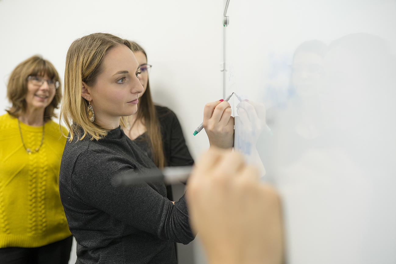 BWL-Studierende arbeiten an Whiteboard.