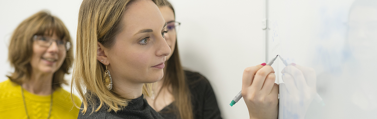 Studierende und Dozentin am Whiteboard