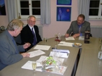 Professor John D. Turner, Dekan an der London South Bank University (links) und rechts Rektor Professor Klaus Fischer, setzen die Unterschriften unter das Abkommen zwischen beiden Hochschulen. In der Mitte Barry Symonds.